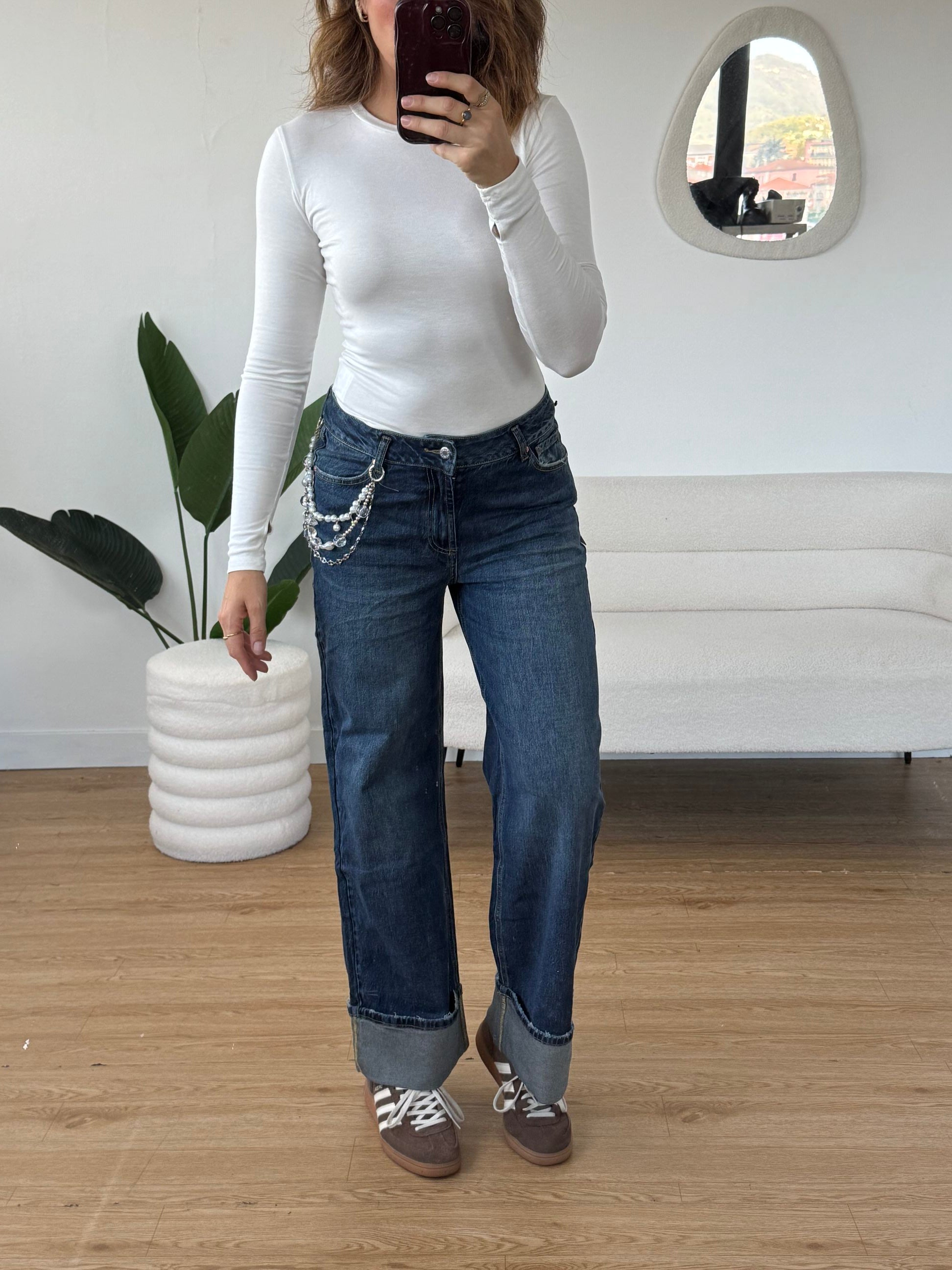 Jeans piegone con catena di perle