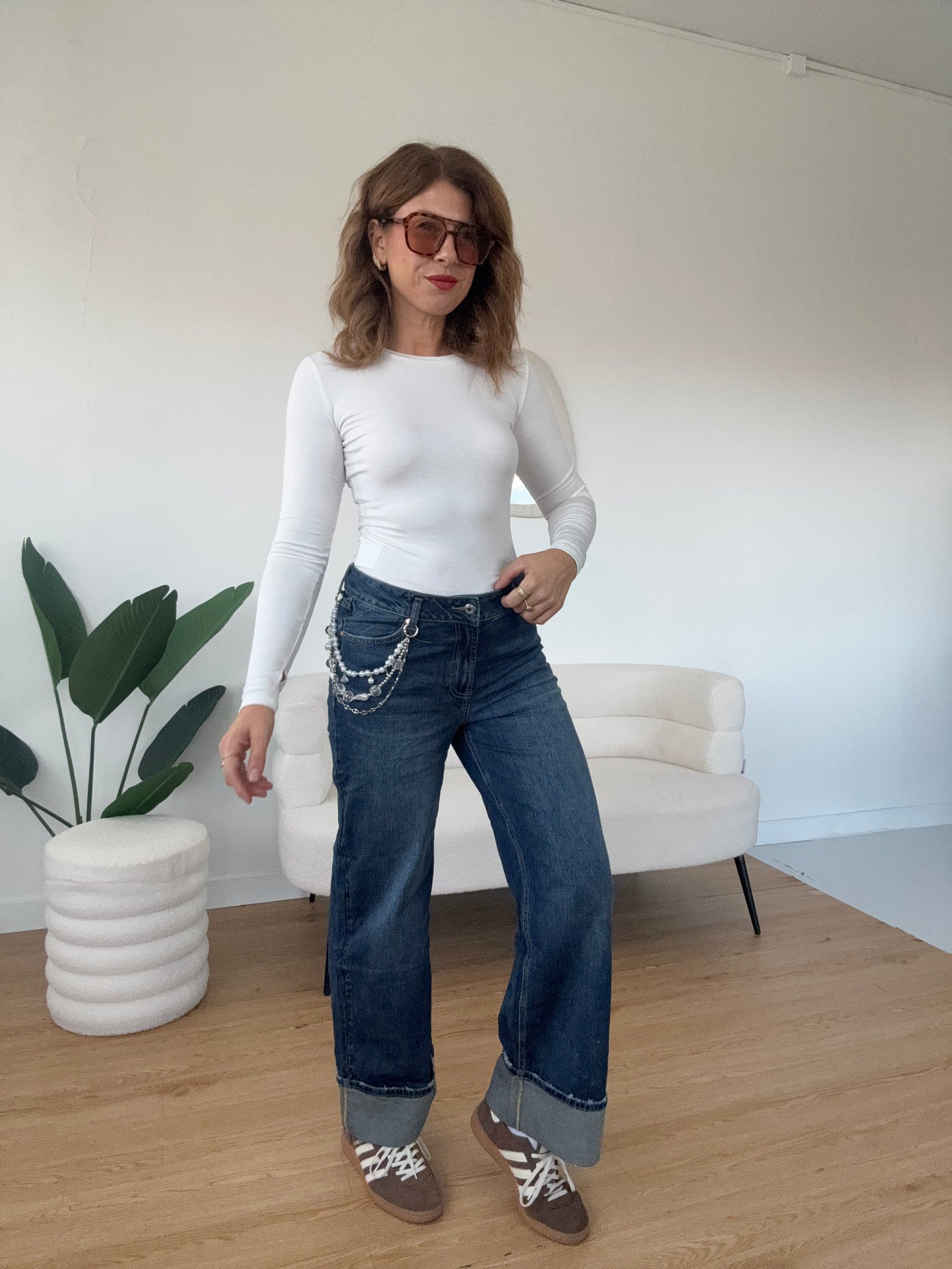 Jeans piegone con catena di perle